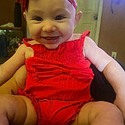 Brinlee joined the competition — help win amazing prizes! baby, child, smiling, red_outfit, headband, indoors, person, happy, sitting, face, arm, cute, infant, portrait, clothing, human, young_child, bright_color, warm_lighting, background