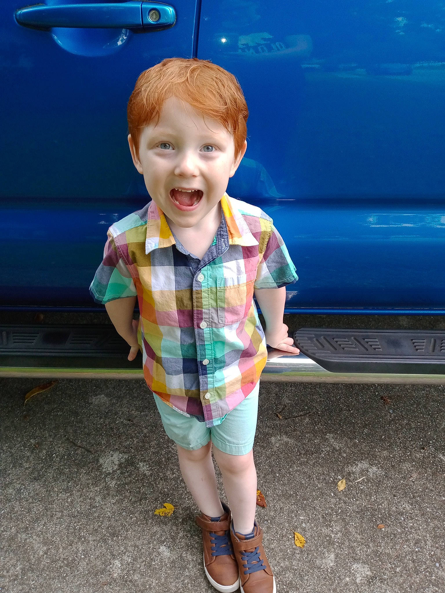 Caedyn is registered to the contest to win money with this photo: automotive_design, automotive_exterior, automotive_lighting, blue, bumper, car, clothing, face, footwear, hair, hood, jeans, leg, motor_vehicle, person, shorts, smile, t_shirt, toddler, vehicle