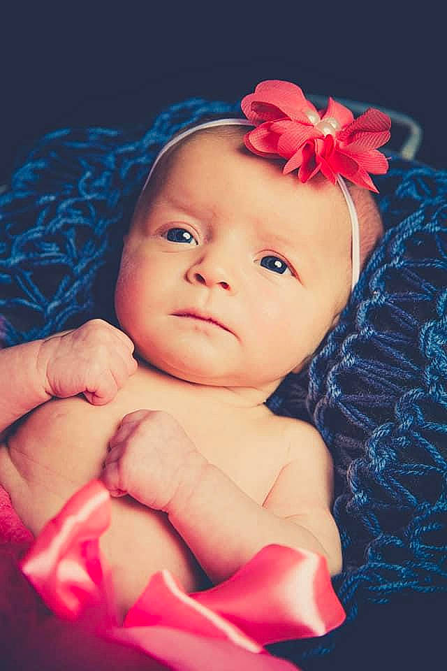 Eléonor participe au concours pour gagner de l'argent avec cette photo : baby, baby_toddler_clothing, blue, cheek, chin, eye, eyebrow, flash_photography, flower, gesture, hand, happy, head, headwear, human, human_body, lip, mouth, person, product