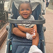 Bryson joined the competition — help win amazing prizes! child, toddler, stroller, shoe, white_shoe, smiling, happy, outdoor, sidewalk, urban, person, baby, clothing, seat, hand, face, hair, cute, city, daylight
