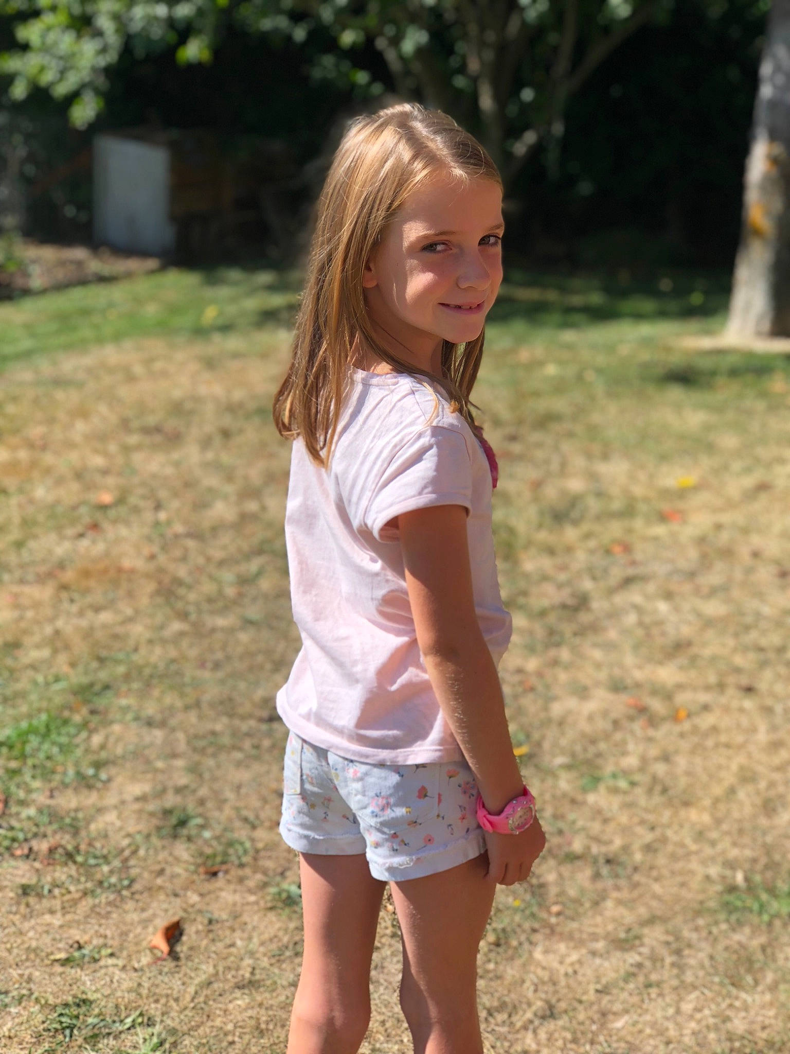 Leana participe au concours pour gagner de l'argent avec cette photo : beauty, blond, child, child_model, fun, grass, joy, long_hair, person, pink, shorts, shoulder, sleeve, smile, style, summer, t_shirt, tree, vacation