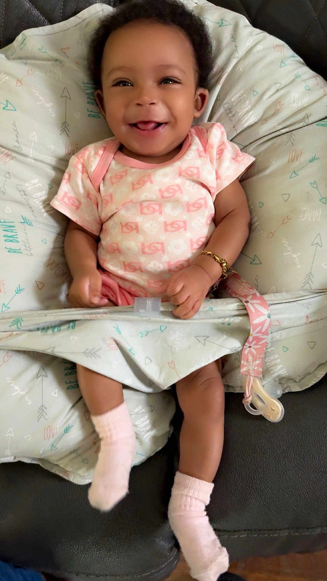 Maziyah joined the competition — help win amazing prizes! baby, smiling, infant, cushion, pink_clothing, socks, bracelet, pacifier, indoor, cute, happy, child, seat, fabric, patterned, relaxed, young, skin, portrait, comfort