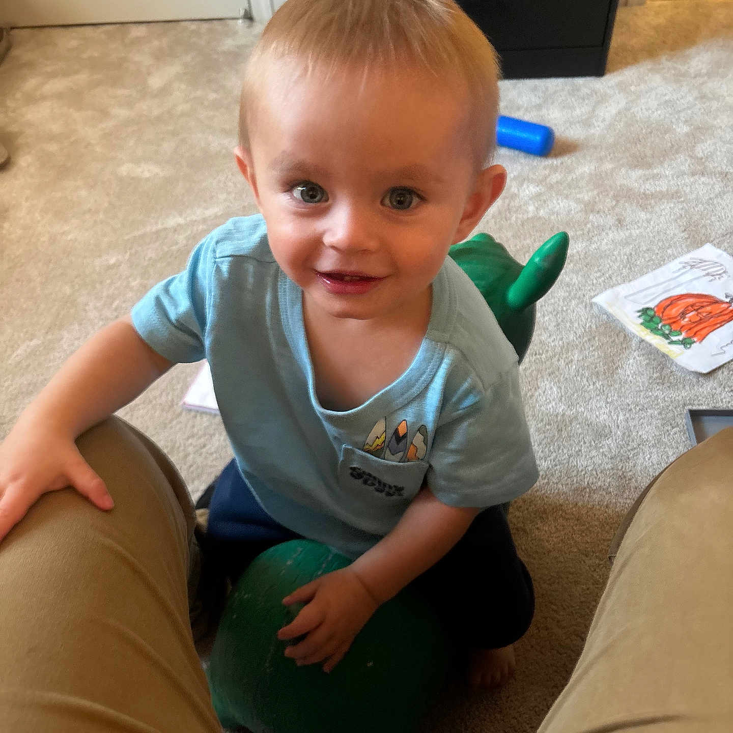 Joshua joined the competition — help win amazing prizes! toddler, child, smiling, indoor, carpet, toy, green, blue_shirt, short_hair, person, drawing, floor, home, playful, happy, kneeling, furniture, cabinet, colorful, casual_clothing