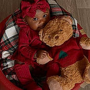 Nyemiah is registered to the contest to win money with this photo: baby, child, teddy_bear, red_clothing, bow, plush_toy, cushioned_chair, wooden_floor, indoor, portrait, cute, smiling, person, infant, holiday_theme, cozy, soft_toy, fashion, sitting, warm_colors