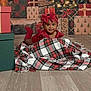 Nyemiah is registered to the contest to win money with this photo: baby, child, red_clothing, bow, plaid_blanket, christmas_presents, holiday, festive, smiling, face, indoors, floor, gift_boxes, decorations, tree, happy, cute, portrait, wrapped_presents, celebration