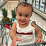 aisle, baby, child, curly_hair, cute, cute_expression, food, grocery_store, happy, indoor, person, pineapple, produce, retail, shopping, shopping_cart, smiling, supermarket, toddler, white_dress