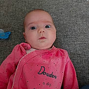 Ilona a rejoint le concours — aidez-le/la à gagner de superbes lots ! baby, infant, pink_clothing, face, drool, pacifier, lying_down, gray_background, curious_expression, child, casual, cute, indoors, portrait, person, young_child, fabric, soft_toys, baby_girl, cozy