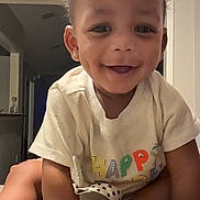 Nasir Cayden is registered to the contest to win money with this photo: toddler, child, smiling, dimples, crawling, indoor, tshirt, happy, face, hand, foot, video_call, adult, doorway, hallway, skin, person, expression, home, family