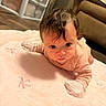 Gabrielle joined the competition — help win amazing prizes! baby, infant, child, face, eyes, portrait, lying_down, tummy_time, pink_blanket, blanket, onesie, socks, brown_hair, indoor, home, couch, wood_floor, cozy, looking_at_camera, cute