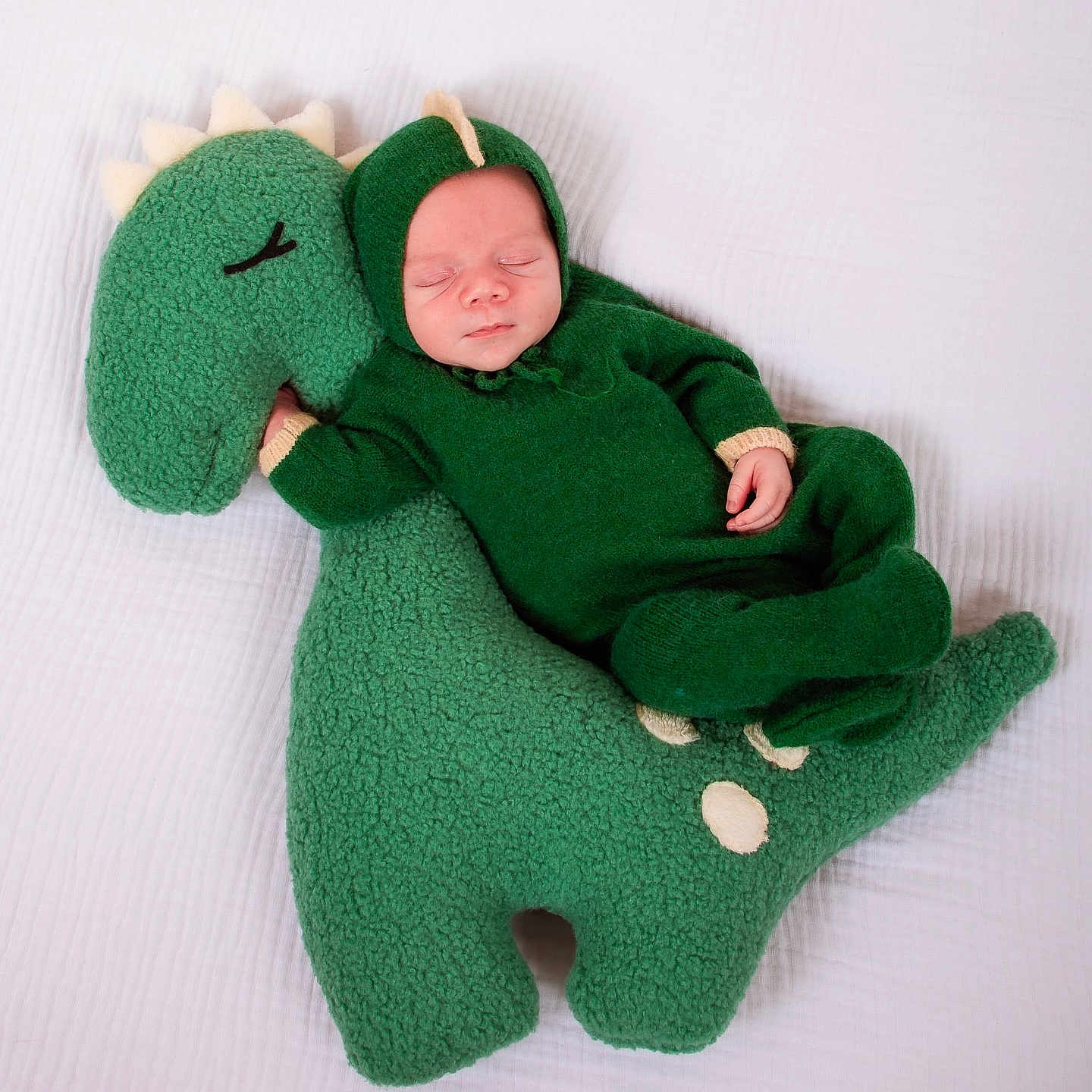 Myles is registered to the contest to win money with this photo: baby, bed, blanket, clothing, costume, cushion, face, furniture, glove, green, hat, head, homedecor, newborn, person, photography, plush, portrait, sleeping, toy