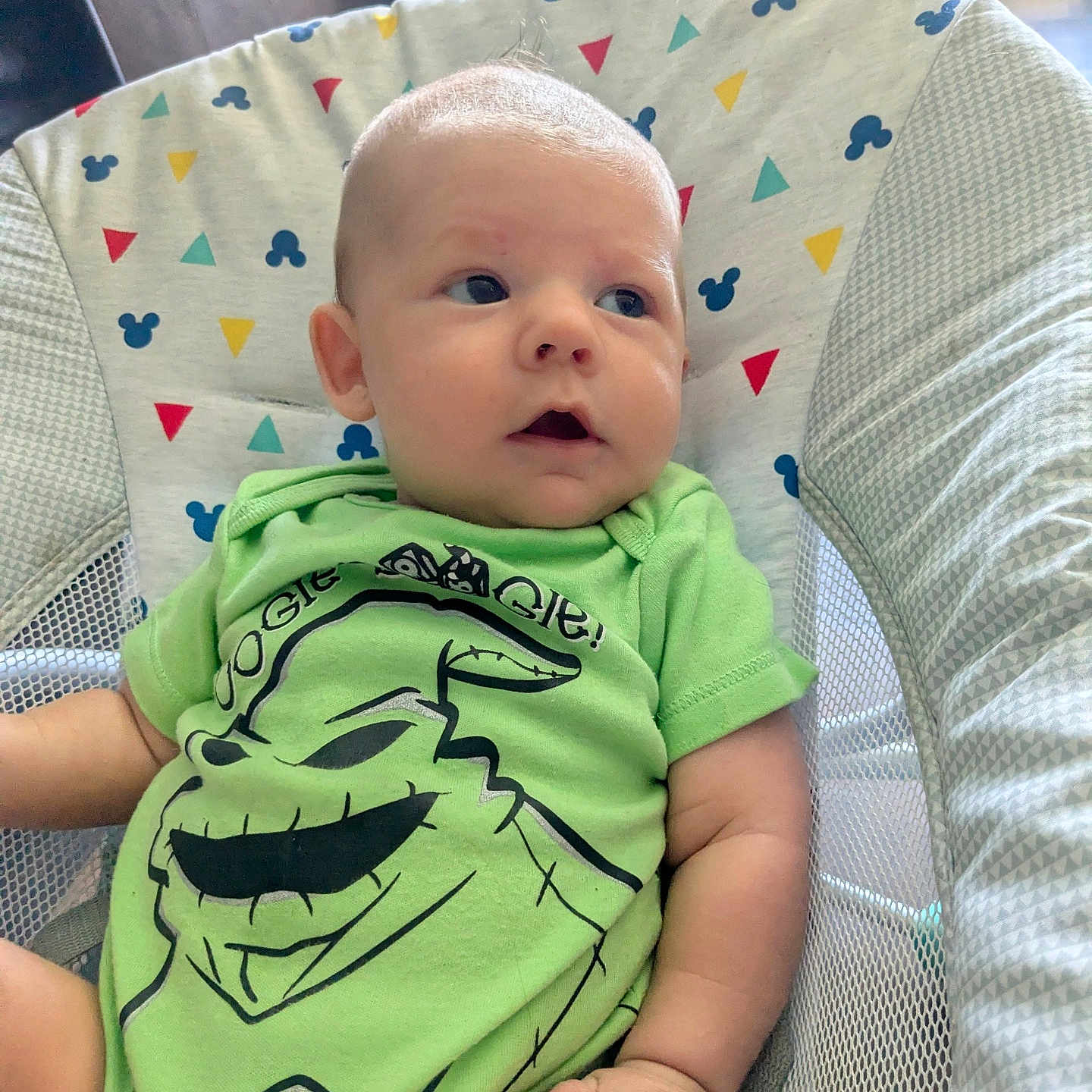 Knoxtin is registered to the contest to win money with this photo: baby, baby_chair, baby_furniture, casual, child, colorful_background, comfortable, curious_expression, cute, green_clothing, human, indoor, infant, mesh_side, onesie, patterned_fabric, portrait, seated, small_hands, soft_lighting