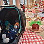 baby, car_seat, pacifier, sleeping, party, indoor, table, tablecloth, decoration, balloons, animal_cutouts, barn, people, adult, hat, chair, event, celebration, fabric, child