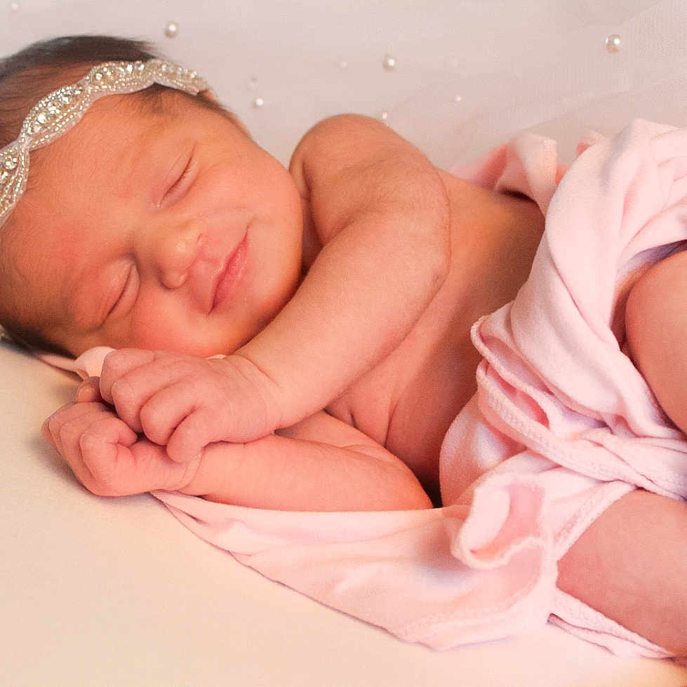 Leanne is registered to the contest to win money with this photo: accessories, baby, bed, blanket, bodypart, clothing, face, finger, furniture, glove, hand, happy, head, headband, jewelry, newborn, person, photography, portrait, sleeping