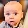 baby, infant, face, eyes, expression, curiosity, closeup, portrait, child, cute, head, skin, cheeks, mouth, clothing, person, indoors, soft_light, blurred_background, young