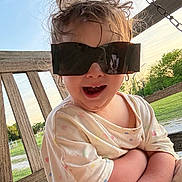 Samantha joined the competition — help win amazing prizes! child, sunglasses, outdoor, swing, wooden, grass, shirt, polka_dot, happy, smile, playful, sunset, nature, arms_crossed, messy_hair, person, casual, fun, portrait, daylight