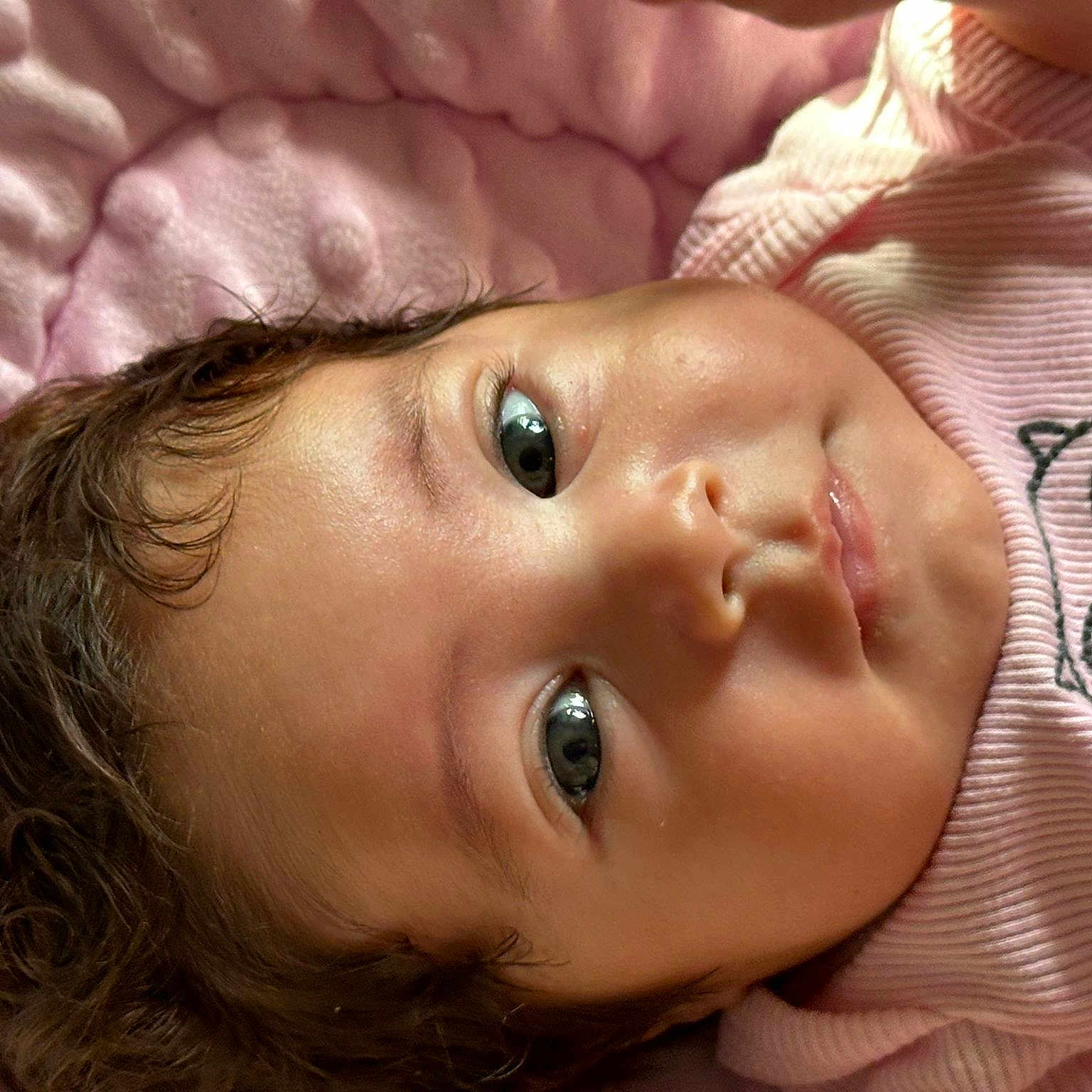 Zoé Ysabella Toledo is registered to the contest to win money with this photo: baby, child, closeup, curly_hair, cute, expression, eyes, face, head, indoors, infant, lying_down, owl_design, pink_blanket, pink_clothing, portrait, skin, soft_texture, toddler, young_child