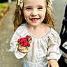 child, girl, smile, flowers, holding, blonde_hair, bows, outdoor, portrait, happy, cute, casual_clothing, nature, daylight, person, young_child, closeup, face, flower_bouquet, background_blur