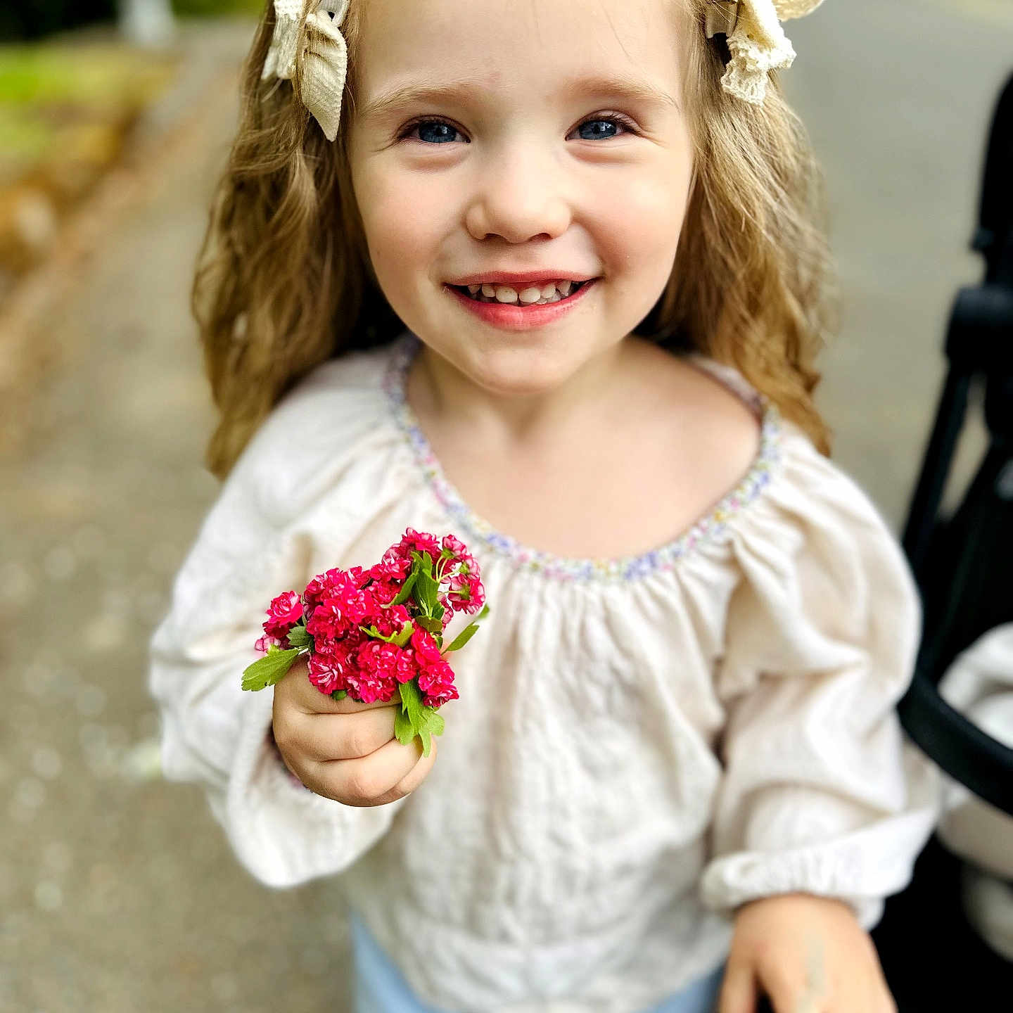 Ivanka joined the competition — help win amazing prizes! child, girl, smile, flowers, holding, blonde_hair, bows, outdoor, portrait, happy, cute, casual_clothing, nature, daylight, person, young_child, closeup, face, flower_bouquet, background_blur