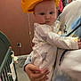 Harper joined the competition — help win amazing prizes! baby, infant, child, person, hat, cheese_hat, nursery, crib, clothing, hand, nail_polish, room, carpet, hanger, wall, decoration, sleepwear, holding, indoor, cute