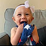baby, child, smiling, headband, bow, blue_cloth, stars, couch, indoor, happy, cute, portrait, toddler, playful, clothing, face, hands, sitting, infant, home