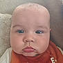 Charlie is registered to the contest to win money with this photo: baby, closeup, face, blue_eyes, pout, bib, red_bib, infant, child, skin, cheeks, expression, portrait, young_child, cute, indoors, soft_background, head, person, clothing