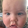baby, face, close_up, blue_eyes, drool, striped_clothing, child, innocent, curious, mouth_open, cheeks, skin, head, person, indoor, portrait, expression, young, cute, infant