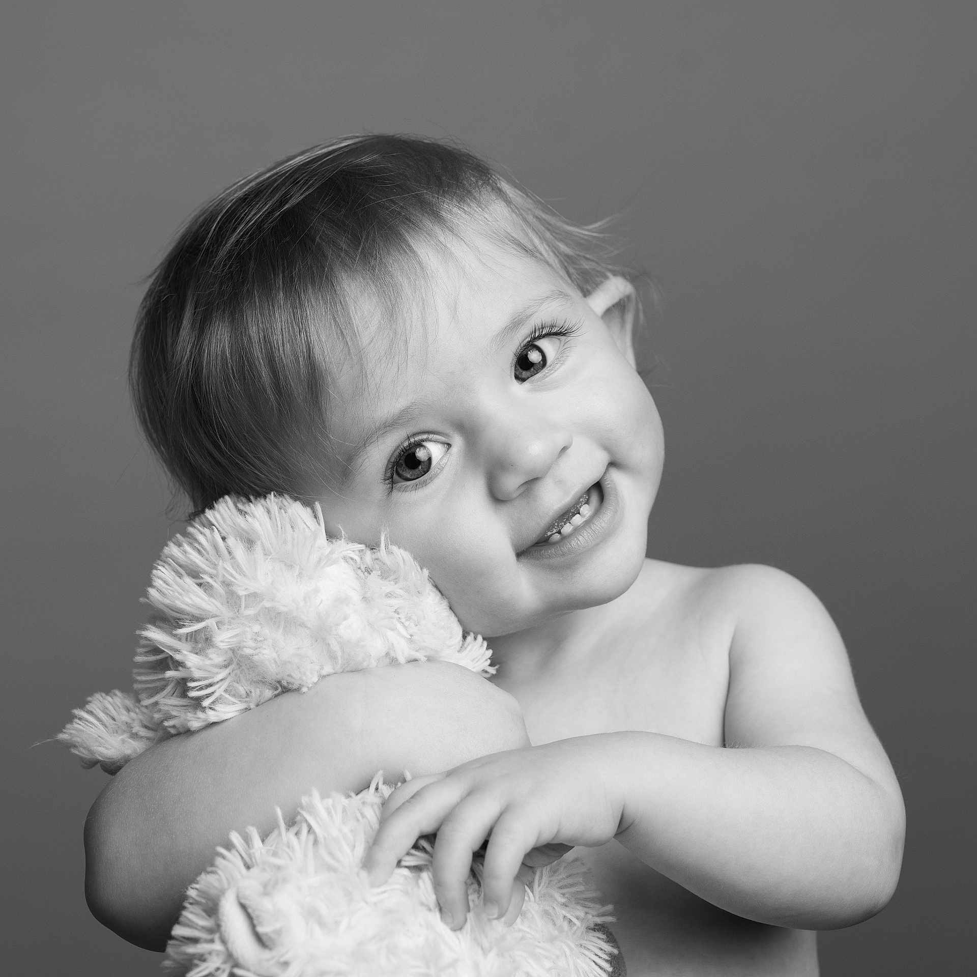 Athena is registered to the contest to win money with this photo: accessories, arm, baby, bodypart, clothing, dress, face, featherboa, finger, hand, happy, head, laughing, mouth, newborn, person, photography, portrait, smile, teeth