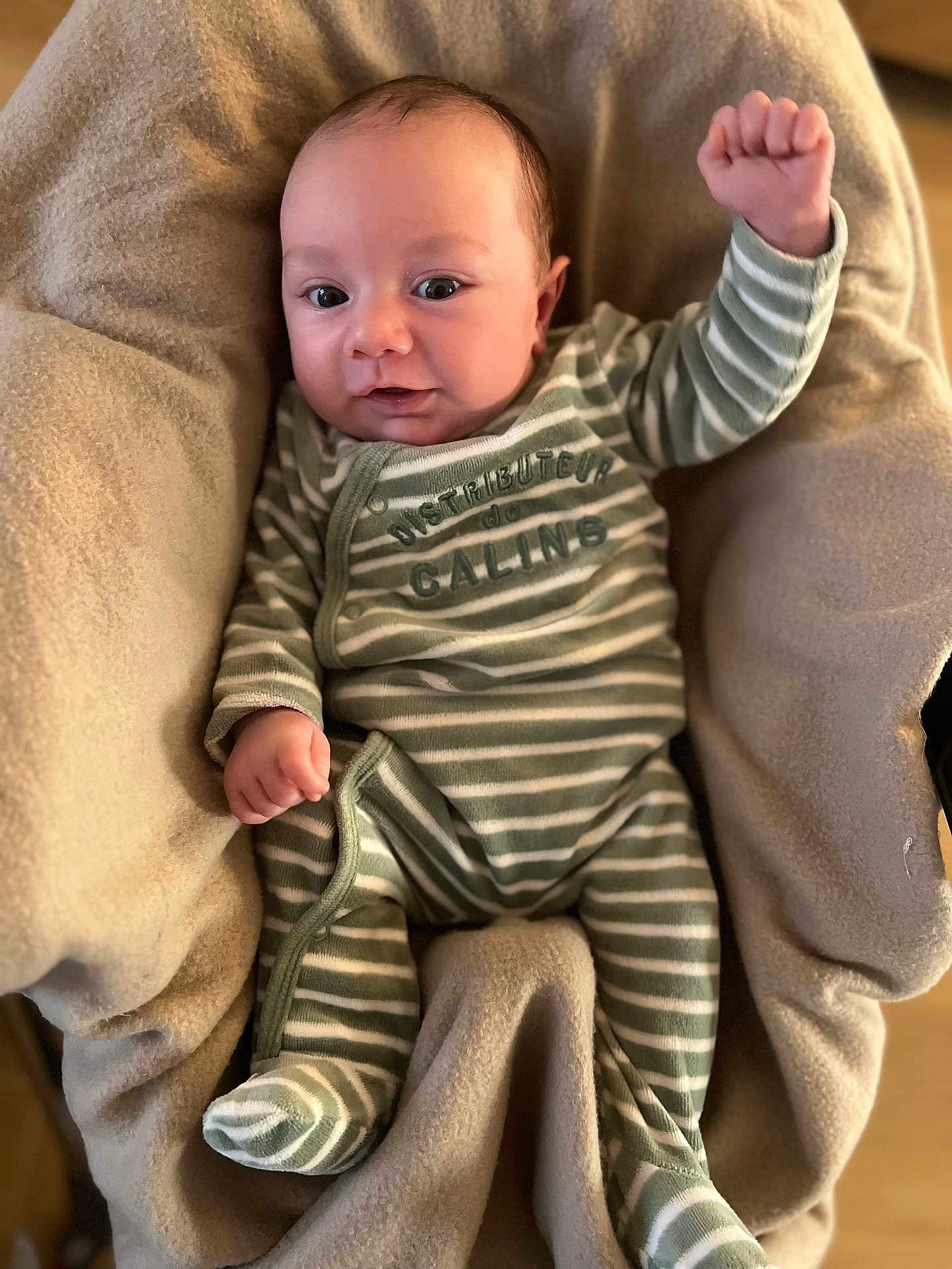 Léon a rejoint le concours — aidez-le/la à gagner de superbes lots ! baby, infant, striped_pajamas, raised_fist, blanket, cozy, smiling, person, child, cute, indoors, soft_texture, portrait, sleepwear, newborn, happy, face, small_hands, lying_down, comfortable