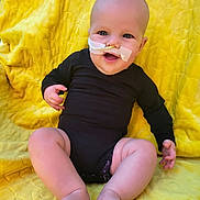 Sawyer joined the competition — help win amazing prizes! baby, infant, child, smiling, portrait, sitting, yellow_blanket, black_onesie, medical_tube, feeding_tube, face, eyes, mouth, bald, indoor, close_up, happy, legs, feet, photography