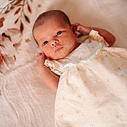 émy participe au concours pour gagner de l'argent avec cette photo : baby, newborn, infant, dress, blanket, floral_pattern, face, eyes, skin, lying_down, soft_texture, cute, small, child, portrait, indoors, peaceful, calm, clothing, sleepwear