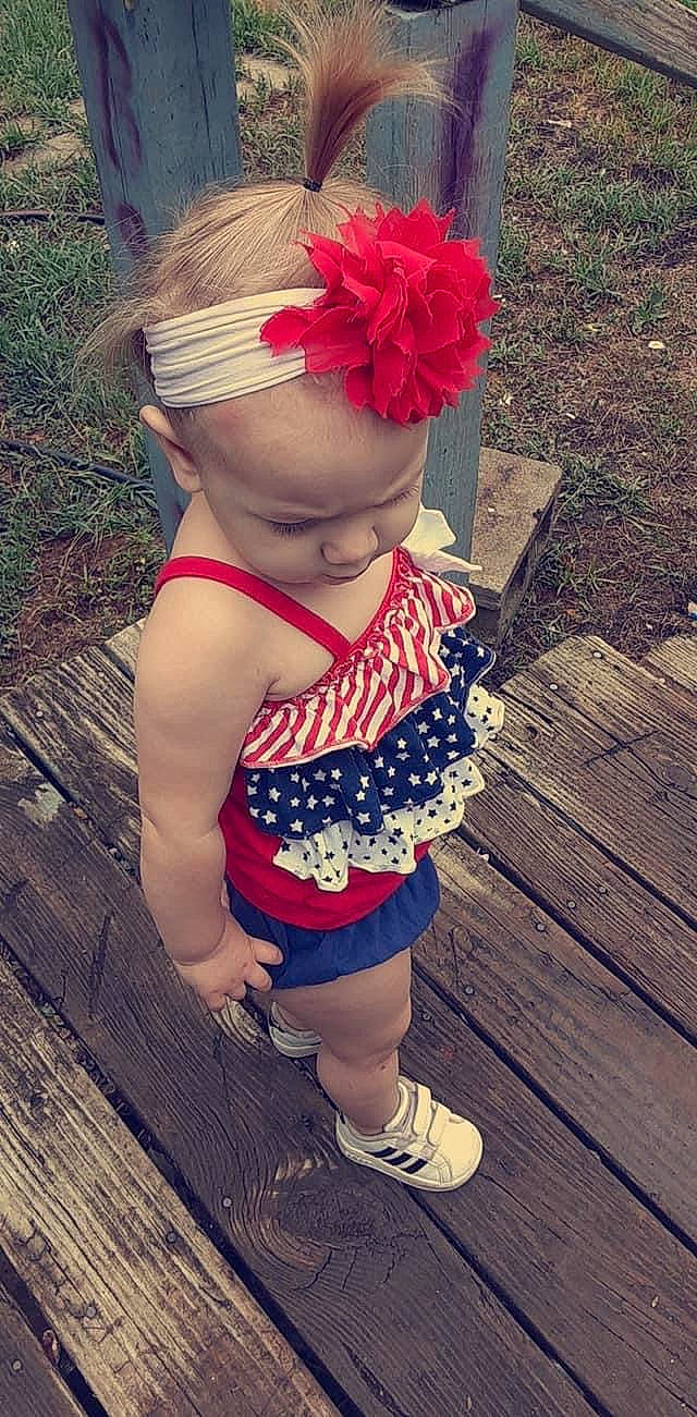 Bella Rose is registered to the contest to win money with this photo: baby, baby_toddler_clothing, child, electric_blue, face, fashion_accessory, grass, hair_accessory, happy, headband, headpiece, human_leg, magenta, pattern, person, personal_protective_equipment, plant, shorts, thigh, toddler