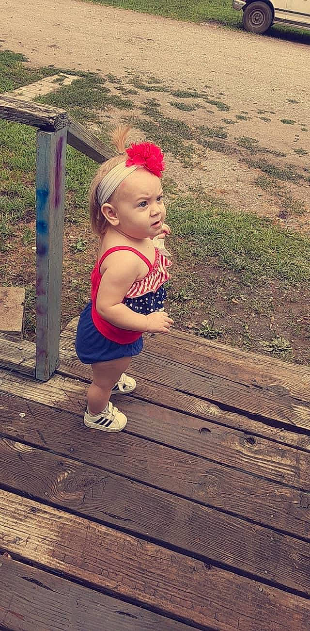 Bella Rose is registered to the contest to win money with this photo: baby, baby_toddler_clothing, child, deck, fence, flooring, fun, grass, happy, hardwood, human_leg, landscape, leisure, metal, people_in_nature, person, plant, recreation, sitting, toddler