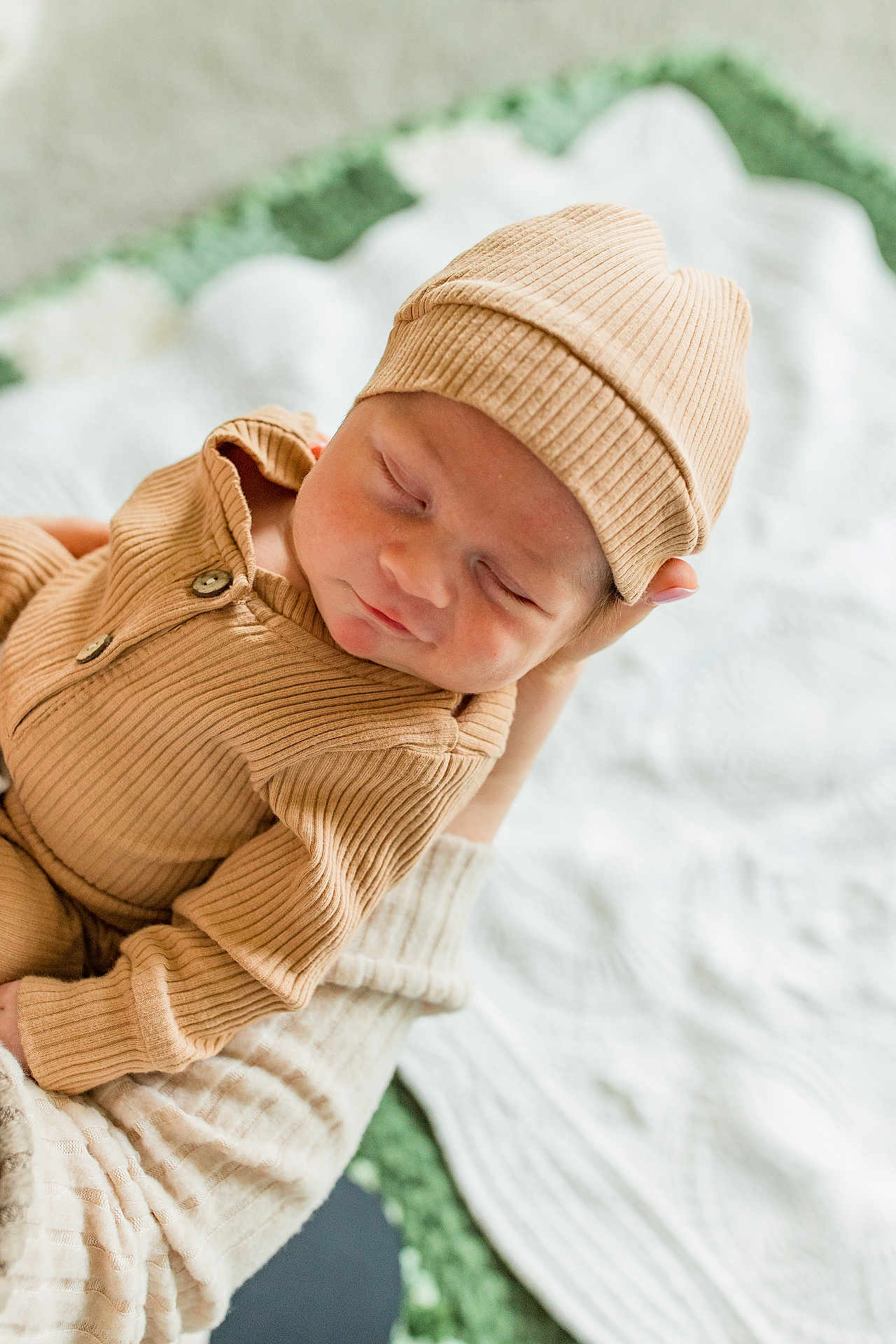 Jaxson joined the competition — help win amazing prizes! baby, newborn, infant, sleeping, hat, knit_hat, beige_clothing, onesie, hand, adult_hand, blanket, bedding, cozy, portrait, closeup, soft_light, buttons, fabric, resting, nursery