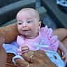 baby, infant, pink_clothing, bow, hand, ring, elderly_person, chain, skin, face, blue_eyes, candid, portrait, closeup, outdoor, holding, love, generations, tenderness, family