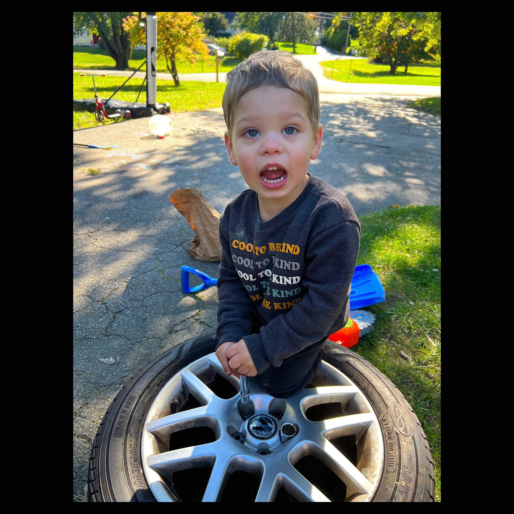 Levi joined the competition — help win amazing prizes! alloy_wheel, automotive_tire, automotive_wheel_system, baby_toddler_clothing, bicycle_tire, fender, grass, happy, hubcap, motor_vehicle, person, plant, rim, surprise, synthetic_rubber, t_shirt, tire, tire_care, toddler, tread
