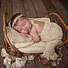 Ashlyn is registered to the contest to win money with this photo: newborn, baby, sleeping, portrait, wicker_basket, blanket, lace, headband, cream_clothing, wooden_floor, indoor, cozy, newborn_photography, curled_up, peaceful, infant, pillow, rustic, barefoot, flower
