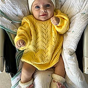 Rose a rejoint le concours — aidez-le/la à gagner de superbes lots ! baby, infant, smile, yellow_sweater, knit_hat, booties, pink_bow, blanket, baby_seat, cozy, cute, child, portrait, happy, indoor, soft_lighting, clothing, face, hands, legs