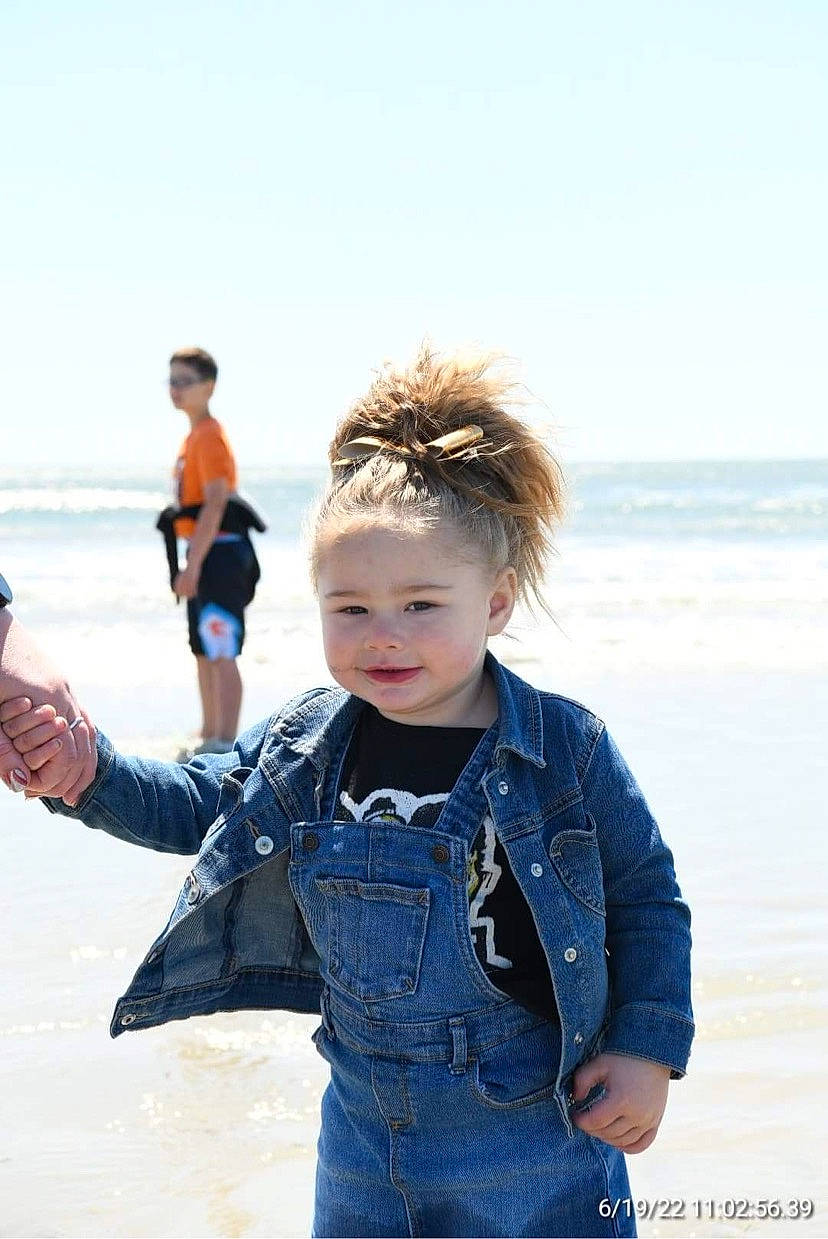 Kamiya is registered to the contest to win money with this photo: baby_toddler_clothing, beach, blurred, child, denim, electric_blue, face, fun, gesture, hand, happy, joy, people_in_nature, person, sky, sleeve, smile, standing, toddler, travel