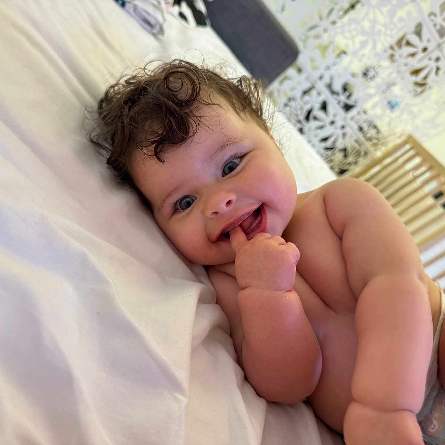 Adalia a rejoint le concours — aidez-le/la à gagner de superbes lots ! baby, bed, cheeks, child, closeup, curly_hair, cute, diaper, expression, finger_in_mouth, happy, indoors, infant, lying_down, nursery, person, playful, skin, smile, soft_light