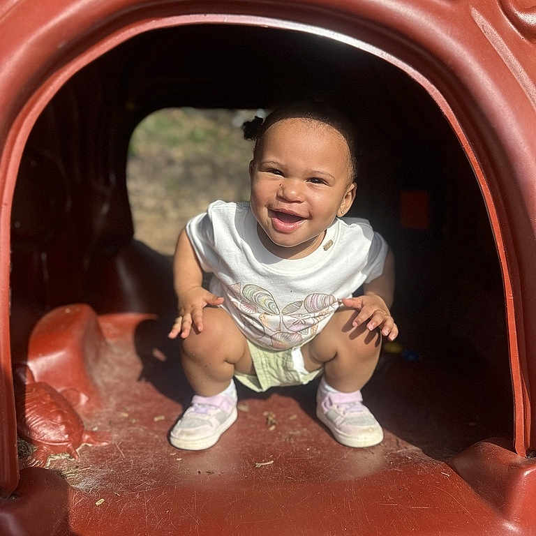 Grace joined the competition — help win amazing prizes! casual_clothing, child, crouching, cute, daylight, face, fun, happy, outdoor, park, person, plastic_playhouse, playground, playtime, smiling, sneakers, sunlight, toddler, white_shirt, young_child