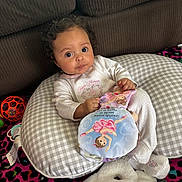 Anaria joined the competition — help win amazing prizes! baby, big_eyes, boppy_pillow, checkered_pillow, child, colorful_carpet, couch, curly_hair, cute_expression, holding_toy, indoor, infant, onesie, patterned_blanket, pillow, playtime, plush_toy, sofa, stuffed_animal, toy_ball