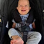 baby, infant, smiling, laughing, stroller, car_seat, harness, buckle, onesie, clothing, bare_feet, toes, legs, head, ears, portrait, cute, happy, black_canopy, closeup
