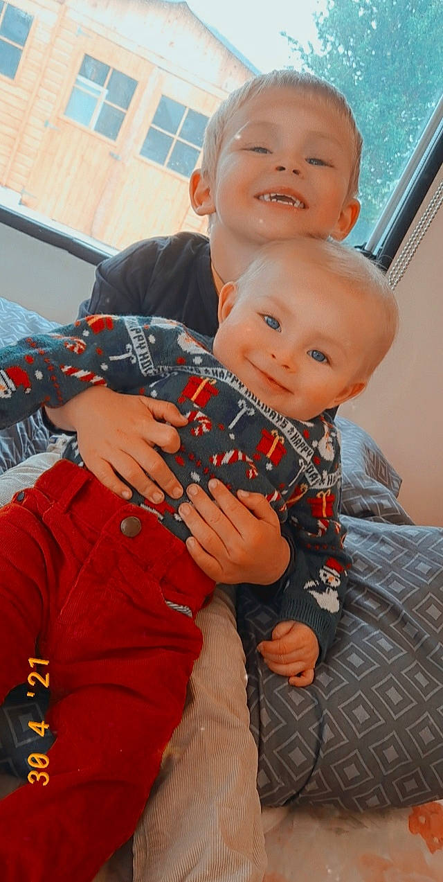 Laydon a rejoint le concours — aidez-le/la à gagner de superbes lots ! baby, baby_toddler_clothing, child, face, fun, gesture, hand, happy, joy, lap, orange, pattern, person, plaid, sitting, skin, sleeve, smile, t_shirt, tartan