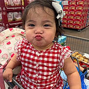 Kristabelle is registered to the contest to win money with this photo: toddler, child, shopping_cart, red_dress, checkered_pattern, hair_bow, grocery_store, pouting, cute, baby, face, person, clothing, retail, supermarket, packaging, sitting, funny_expression, indoor, hand