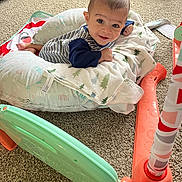Adnan joined the competition — help win amazing prizes! baby, infant, child, smiling, face, portrait, lying_down, play_mat, pillows, blanket, striped_clothing, long_sleeves, indoor, living_room, carpet, toy, play_gym, colorful, home, happy