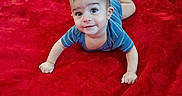 Adnan is registered to the contest to win money with this photo: baby, child, infant, portrait, lying_down, red_blanket, blue_shirt, smiling, curious, face, eyes, arms, hands, feet, indoor, close_up, crawling, soft_blanket, adorable, photography