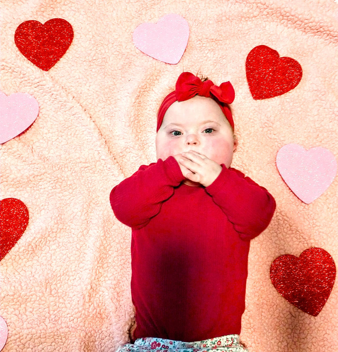 Evie is registered to the contest to win money with this photo: baby, baby_toddler_clothing, beauty, carmine, child, christmas, christmas_eve, event, facial_expression, gesture, happy, headwear, holiday, magenta, organ, pattern, person, pink, red, sleeve