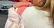 Leilani is registered to the contest to win money with this photo: baby, child, woman, blonde_hair, headband, bow, blanket, indoor, window, table, shoulder, hug, affection, face, person, clothing, curious, pink, white_shirt, closeup