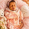 baby, sleeping, pink_clothing, headband, blanket, teddy_bear, pillow, heart_shape, soft_texture, cozy, cute, newborn, peaceful, indoor, portrait, child, infant, resting, warm_lighting, decor