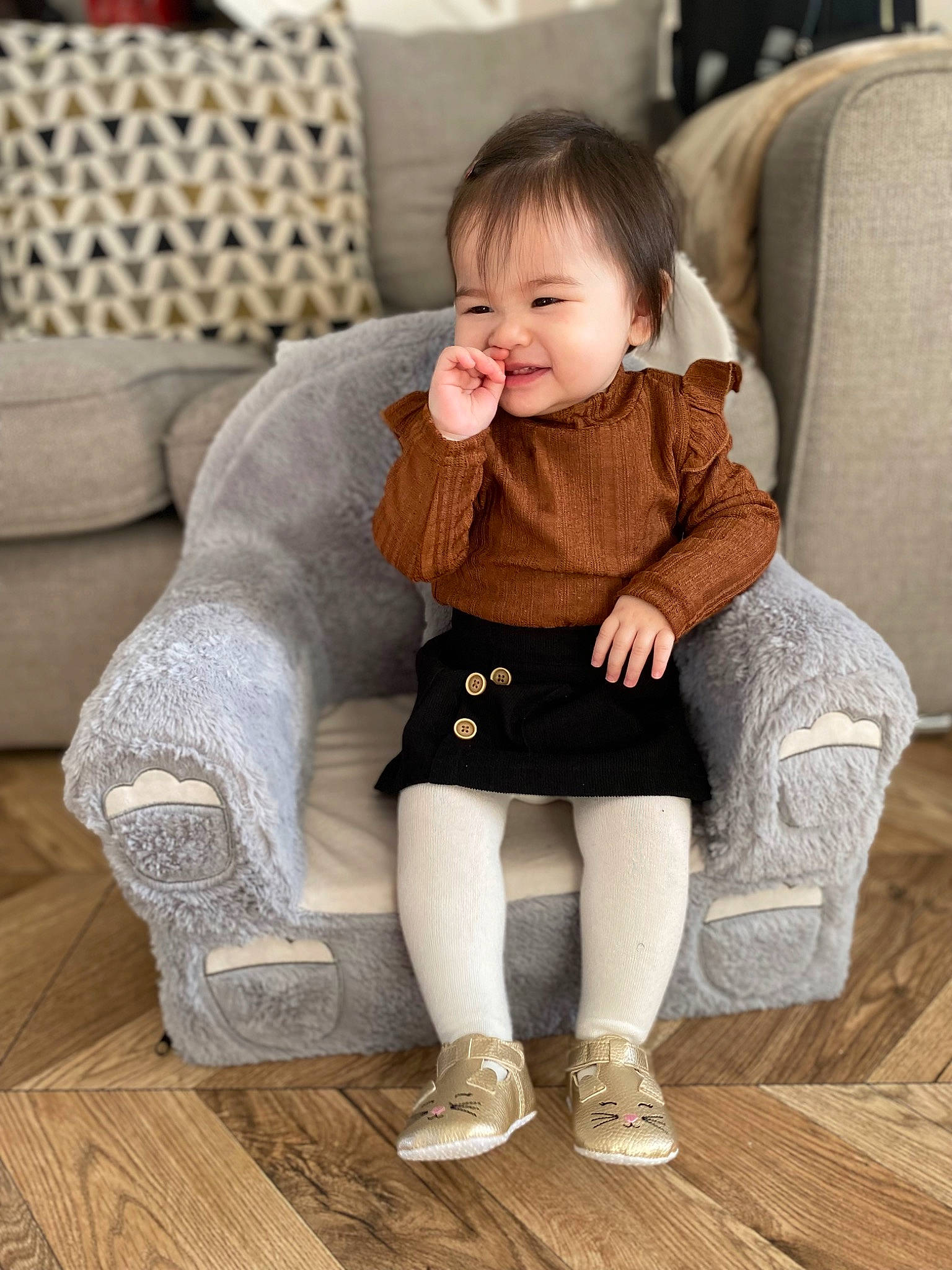 Indie is registered to the contest to win money with this photo: baby_toddler_clothing, comfort, couch, dress, eye, face, floor, flooring, hair, happy, hardwood, head, knee, leg, person, shoe, sleeve, smile, toddler, white